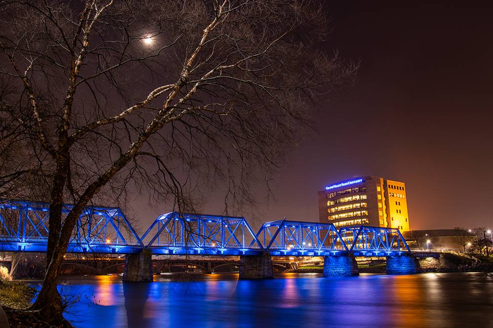 GVSU Building lit up during the night over looking Blue Bridge